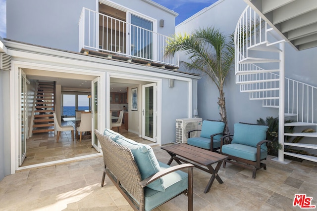 view of patio featuring ac unit and a balcony