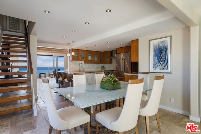 dining room featuring sink and a water view