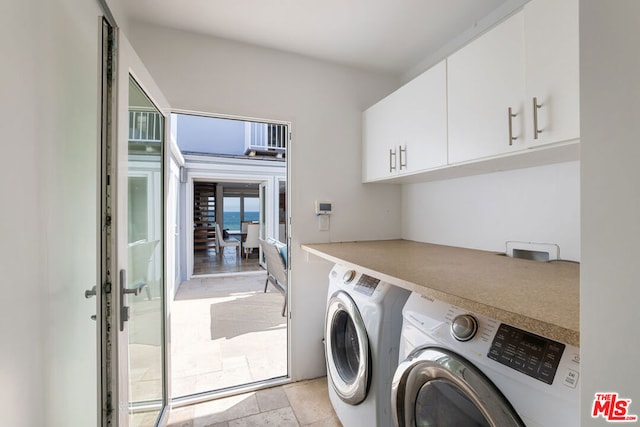 laundry area with washer and clothes dryer and cabinets