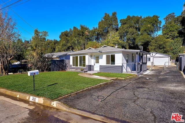 view of front of home featuring an outbuilding, a front lawn, and a garage