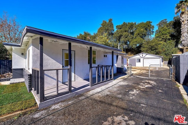 exterior space with an outbuilding, covered porch, and a garage