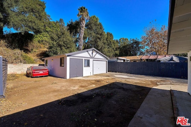 view of yard with a garage and an outbuilding