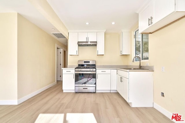 kitchen with light wood-type flooring, white cabinetry, gas stove, and sink