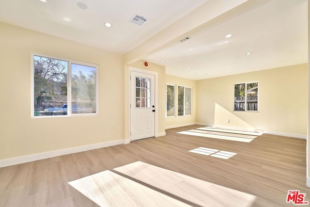 interior space featuring beam ceiling and light wood-type flooring