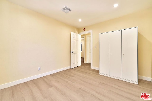 unfurnished bedroom featuring a closet and light hardwood / wood-style flooring