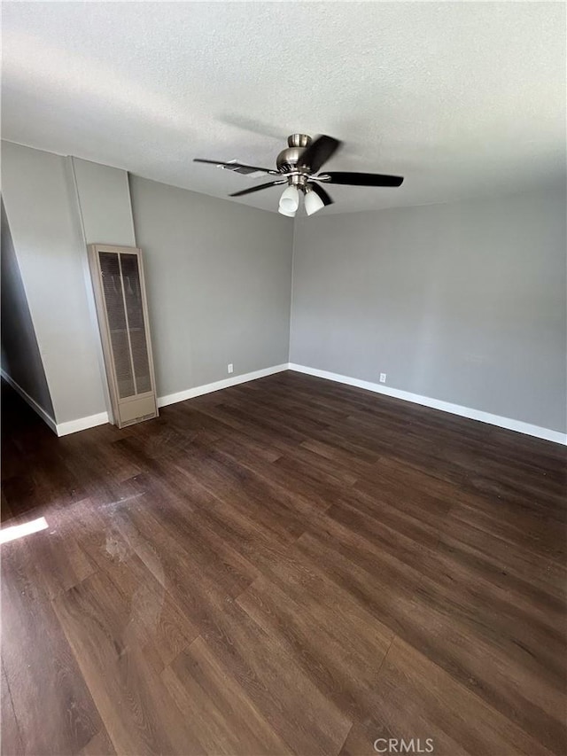 spare room with ceiling fan, dark hardwood / wood-style flooring, and a textured ceiling