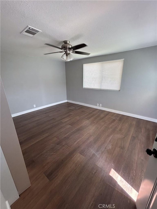 unfurnished room with a textured ceiling, ceiling fan, and dark hardwood / wood-style flooring