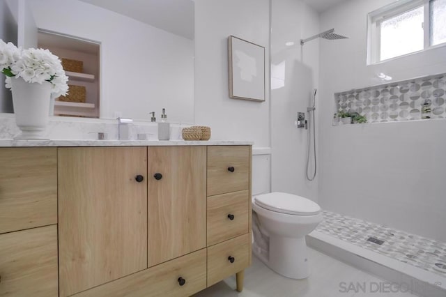 bathroom featuring toilet, walk in shower, and vanity