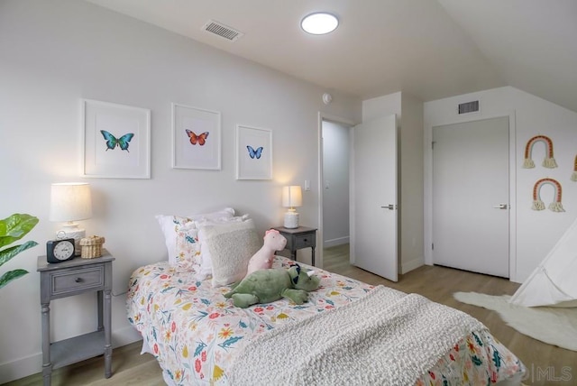 bedroom featuring vaulted ceiling and light hardwood / wood-style floors