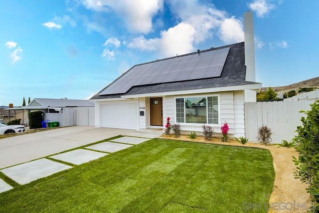 view of front of home with a front yard, a garage, and solar panels