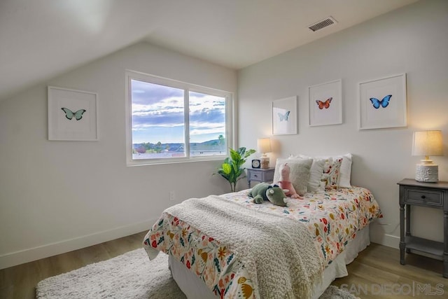 bedroom featuring vaulted ceiling and light hardwood / wood-style floors