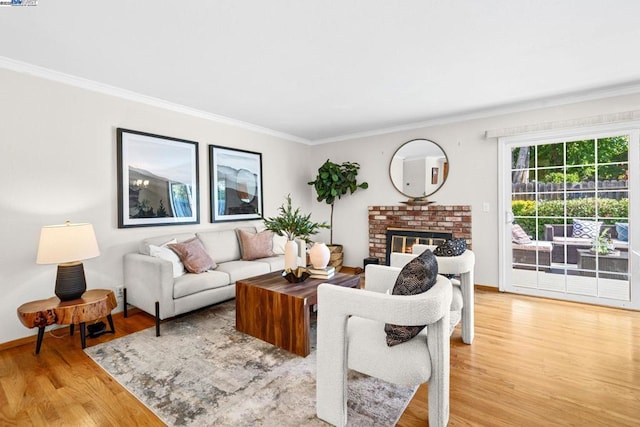 living room featuring wood-type flooring, a brick fireplace, and crown molding