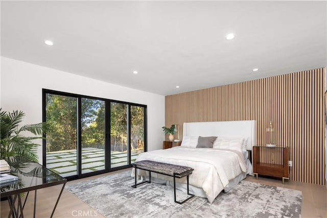 bedroom with access to exterior and light hardwood / wood-style flooring