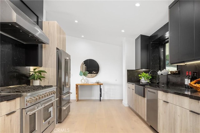 kitchen featuring extractor fan, light brown cabinets, sink, light hardwood / wood-style flooring, and high quality appliances