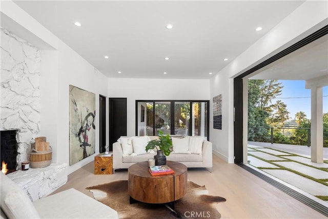 living room featuring light hardwood / wood-style floors, a fireplace, and french doors