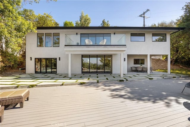 rear view of house with a deck and a balcony