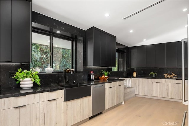 kitchen featuring tasteful backsplash, light brown cabinetry, sink, light wood-type flooring, and stainless steel dishwasher