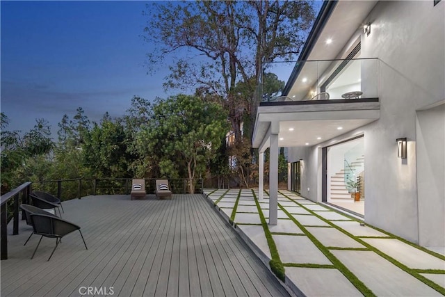 deck at dusk featuring a patio