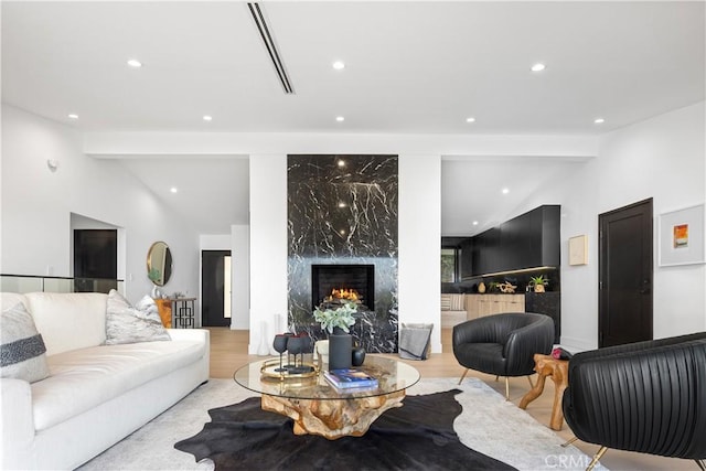 living room with a high end fireplace and lofted ceiling with beams