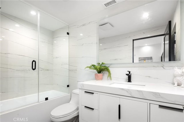 full bathroom with toilet, enclosed tub / shower combo, and vanity