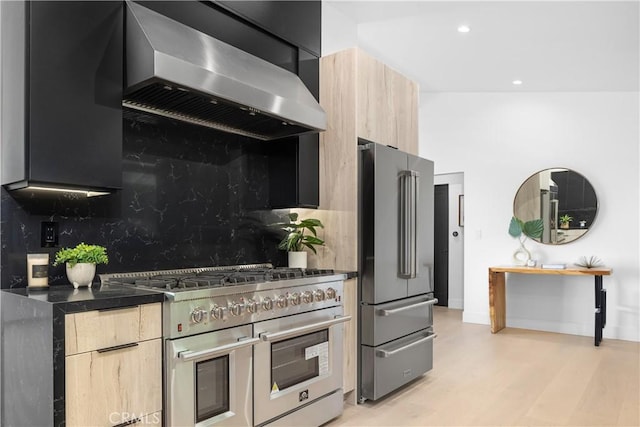 kitchen with decorative backsplash, light brown cabinetry, extractor fan, and high quality appliances