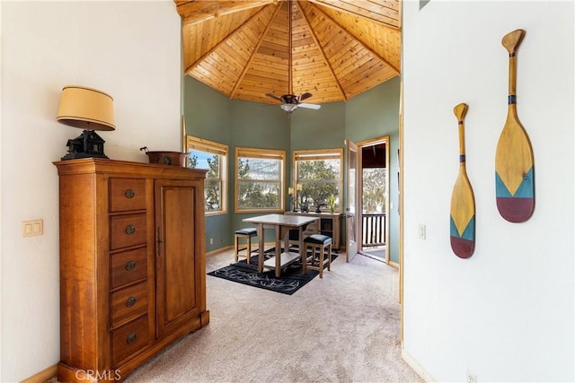 dining area with ceiling fan, light colored carpet, wooden ceiling, and high vaulted ceiling