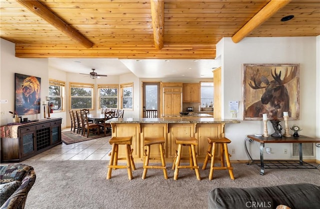 kitchen featuring beam ceiling, wooden ceiling, light colored carpet, and kitchen peninsula