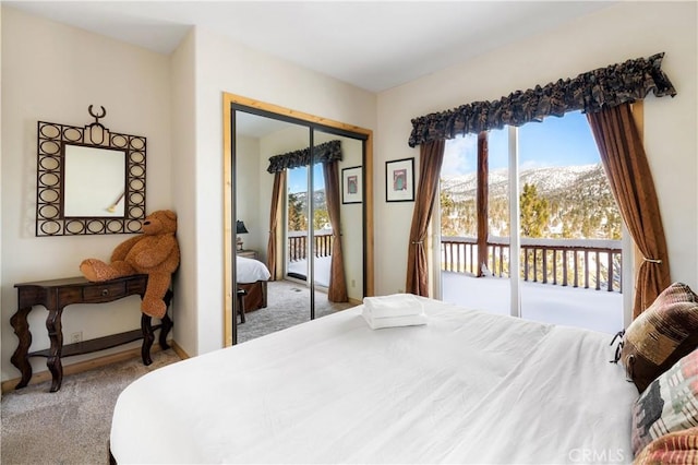 bedroom with access to outside, a closet, a mountain view, and carpet floors