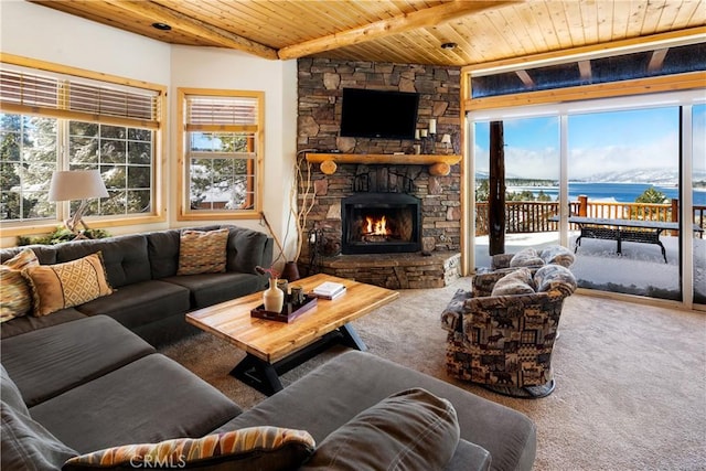 carpeted living room featuring wooden ceiling, beamed ceiling, a stone fireplace, and a healthy amount of sunlight