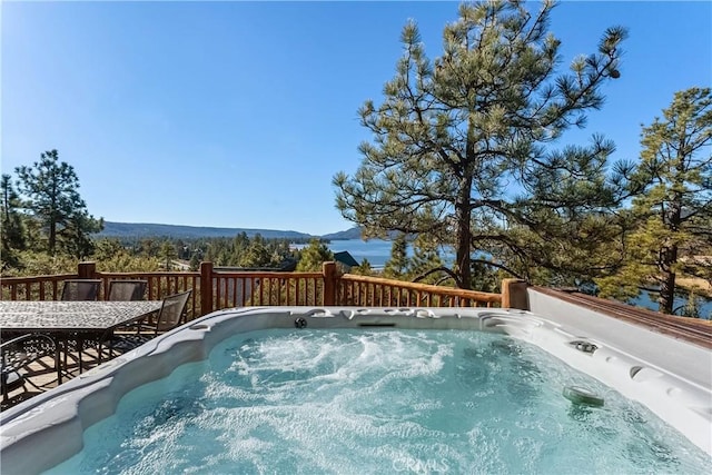 view of pool featuring a hot tub and a deck with mountain view