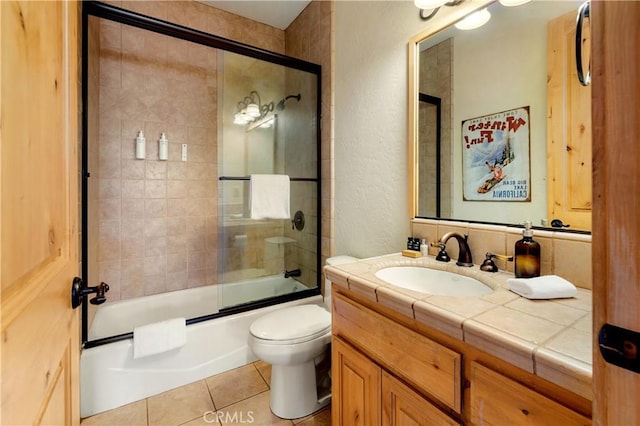 full bathroom with toilet, vanity, tile patterned floors, and shower / bath combination with glass door