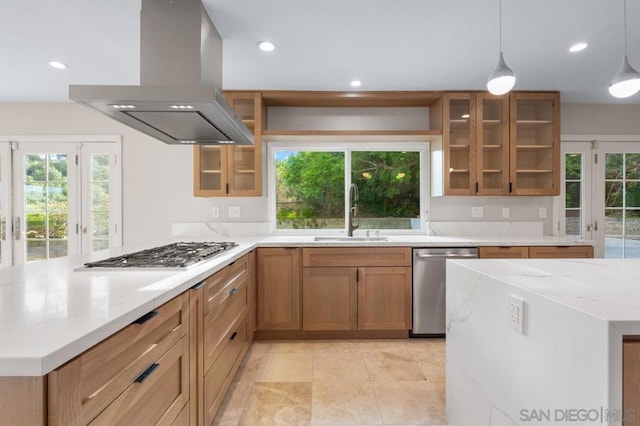 kitchen featuring pendant lighting, island exhaust hood, sink, light stone countertops, and stainless steel appliances