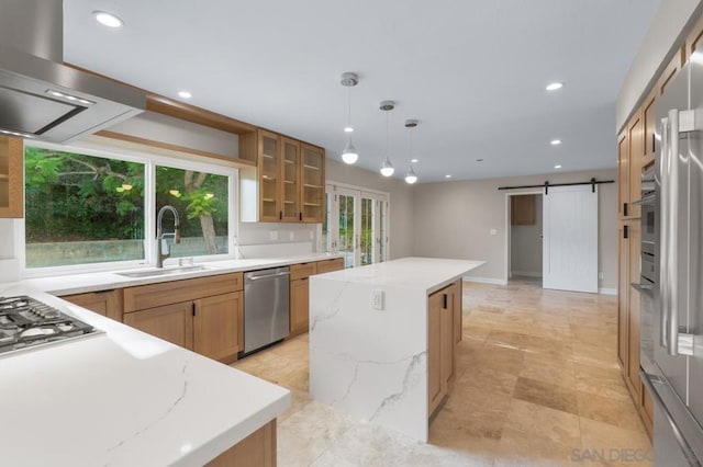 kitchen featuring a barn door, a center island, sink, hanging light fixtures, and stainless steel appliances