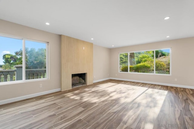 unfurnished living room with a large fireplace and light hardwood / wood-style flooring