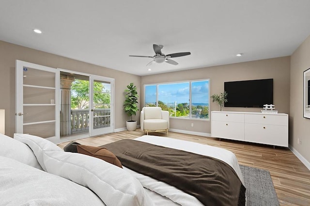 bedroom featuring ceiling fan, access to exterior, light hardwood / wood-style floors, and multiple windows