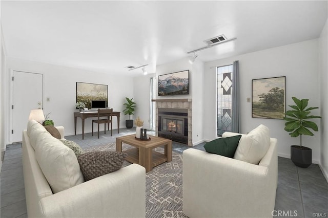 living room featuring tile patterned flooring, a tile fireplace, and track lighting