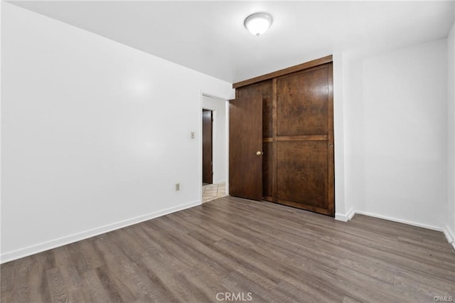 unfurnished bedroom with a closet and hardwood / wood-style floors