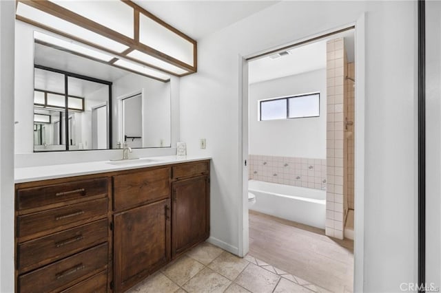 bathroom featuring a bathtub, toilet, vanity, and tile patterned flooring