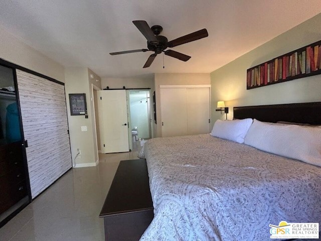 bedroom featuring ceiling fan and a barn door