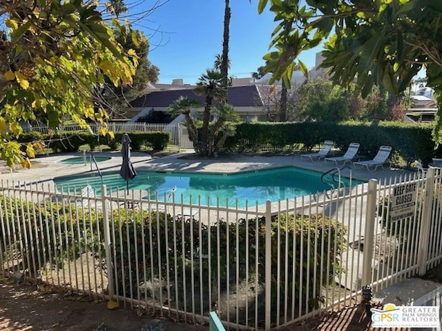 view of swimming pool featuring a patio area and a hot tub