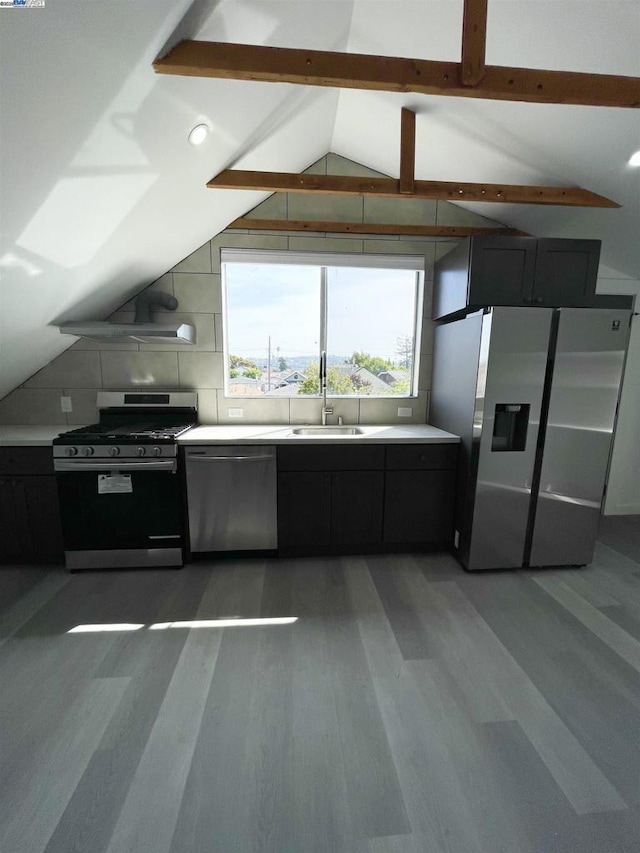 kitchen featuring lofted ceiling with beams, appliances with stainless steel finishes, sink, and wood-type flooring