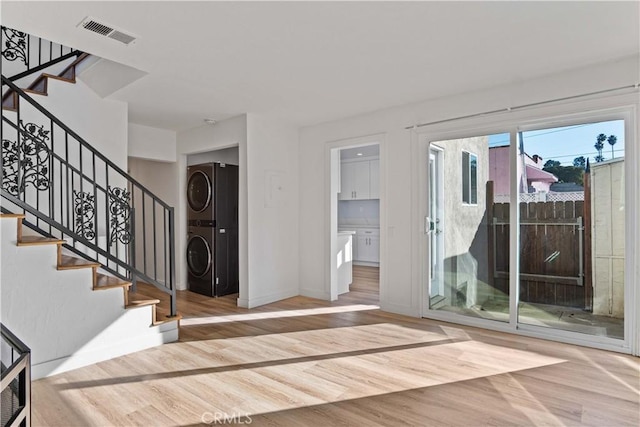 foyer featuring stacked washer / dryer and hardwood / wood-style floors