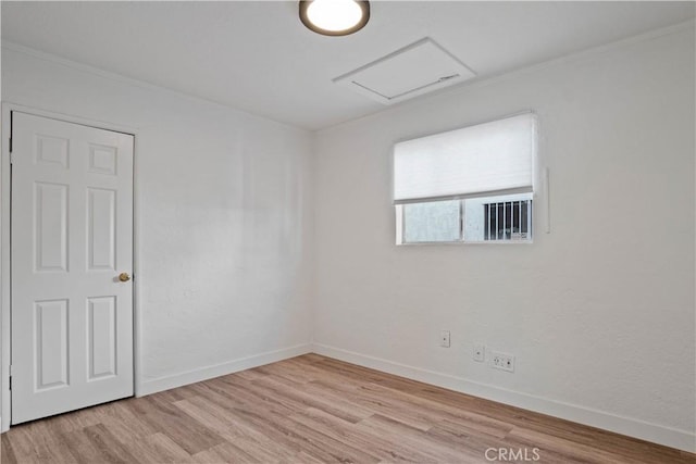 unfurnished room with light wood-type flooring and crown molding