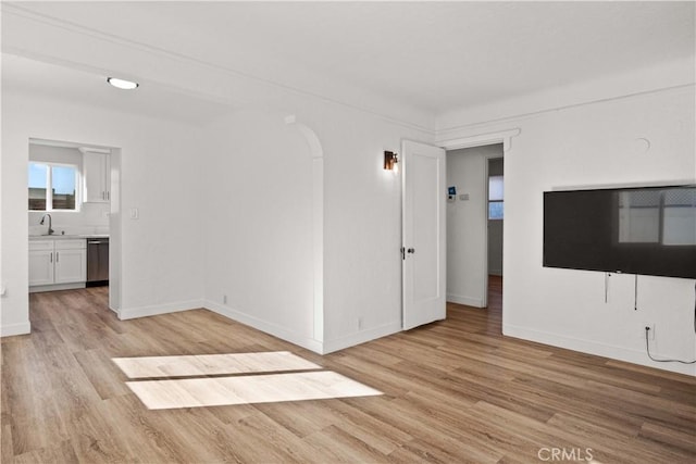 unfurnished living room featuring light wood-type flooring and sink