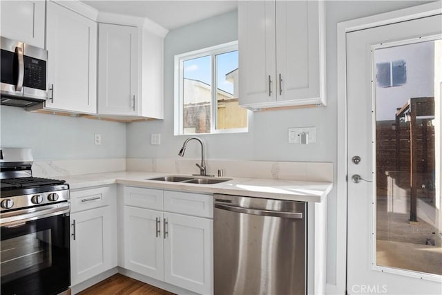 kitchen with sink, white cabinets, dark hardwood / wood-style floors, and stainless steel appliances