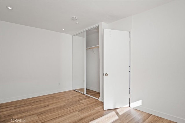 unfurnished bedroom featuring light wood-type flooring and a closet