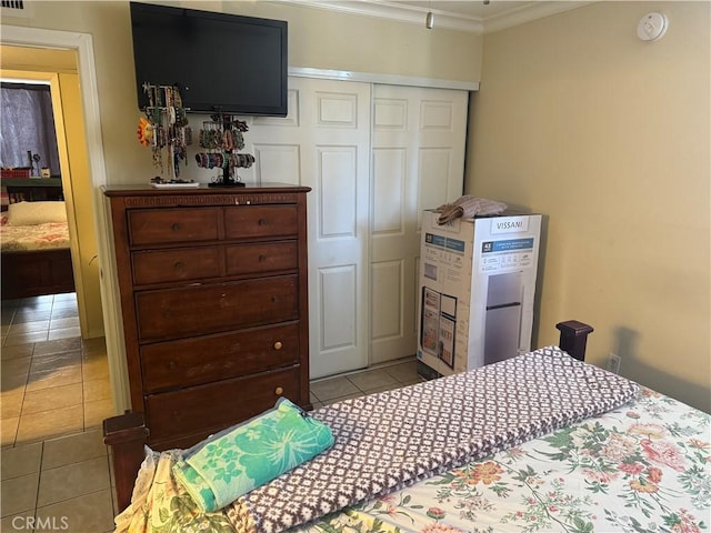 tiled bedroom with a closet and ornamental molding