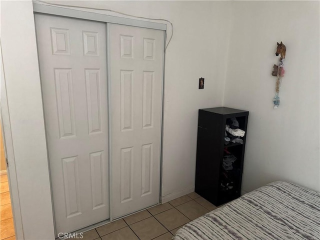 tiled bedroom with a closet