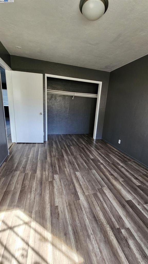 unfurnished bedroom featuring a closet and wood-type flooring