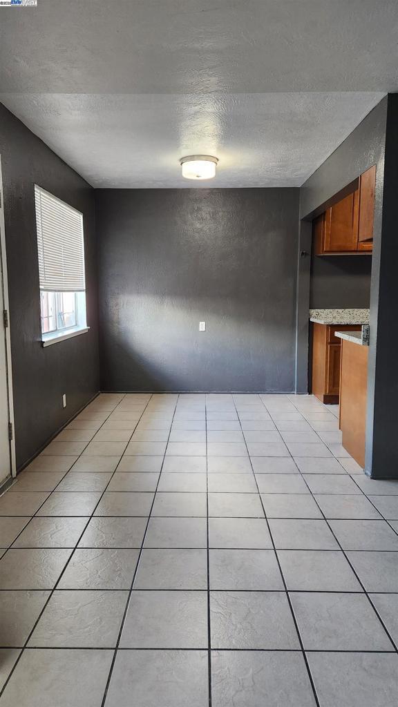 interior space with a textured ceiling and light tile patterned floors